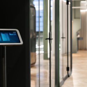 Dunkle Framery One Compact neben Arbeitsplätzen im Grossraumbüro