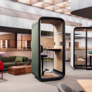 Framery One Compact zwischen Schreibtischen eines modernen Büros